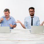 The two colleagues working together at office on white background